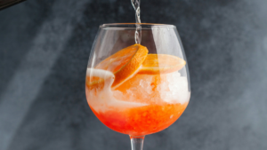Osvežilni Aperol Spritz koktajl s pomarančo in ledom v kozarcu za vino