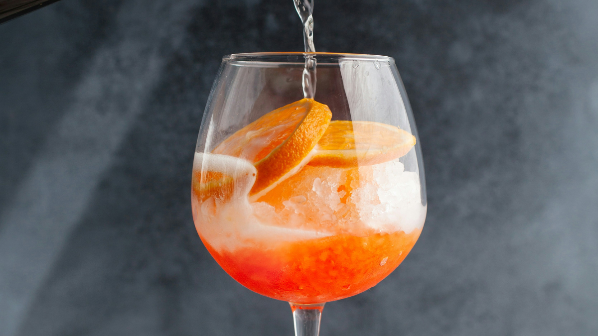 Osvežilni Aperol Spritz koktajl s pomarančo in ledom v kozarcu za vino